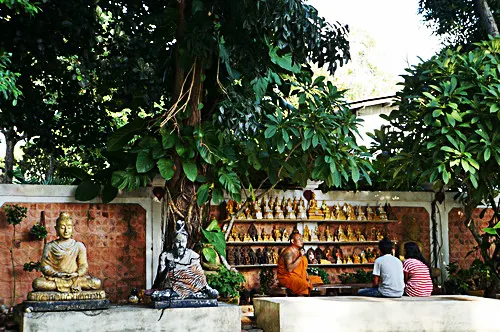 A monk talking to visitors at Wat Khunaram
